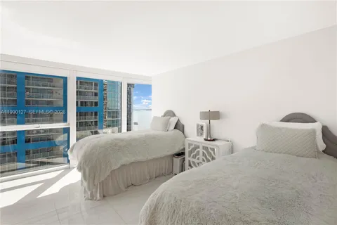 a bedroom with two beds and window
