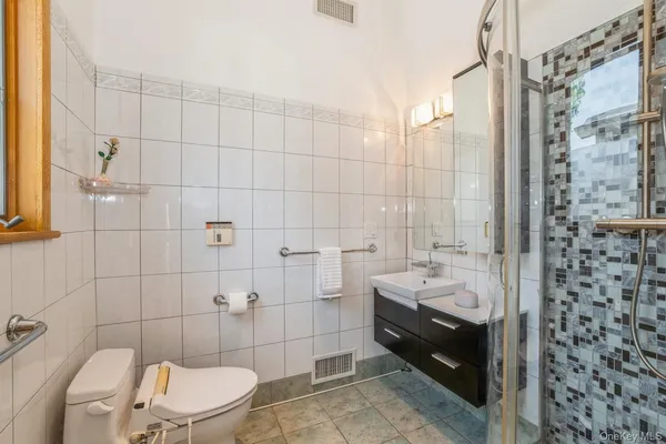 a bathroom with a sink a toilet and shower
