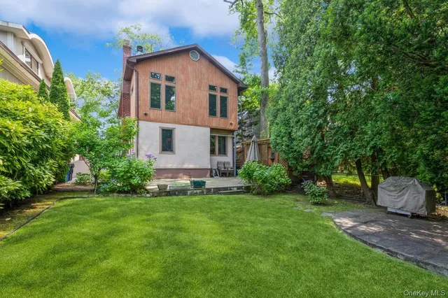 a front view of a house with a yard and trees