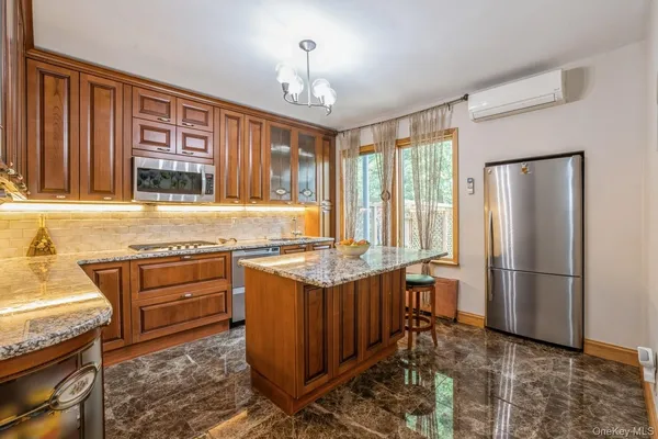 a kitchen with stainless steel appliances granite countertop a stove top oven a refrigerator and a sink with granite countertops