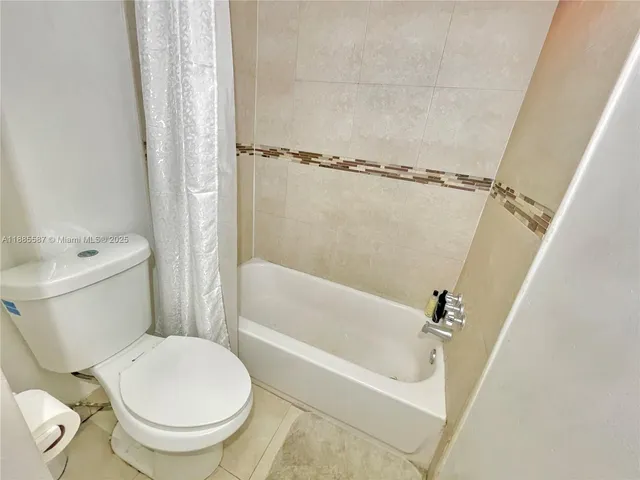 a white toilet sitting next to a bath tub