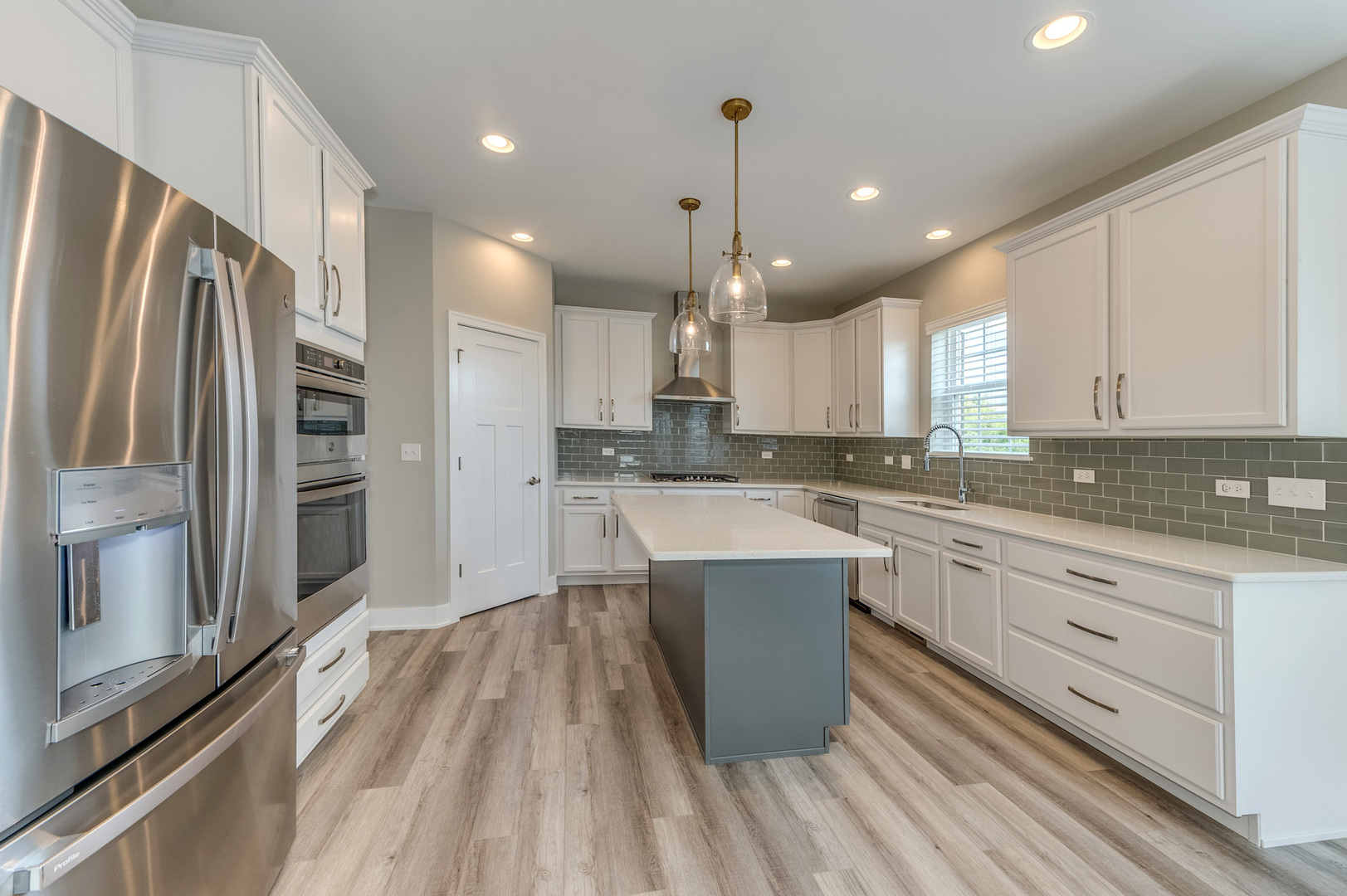 13101 Kettering Way Lemont, IL 60439 - Photo 11 of 36 a large kitchen with stainless steel appliances kitchen island granite countertop a refrigerator a sink dishwasher a stove and white countertops with wooden floor
