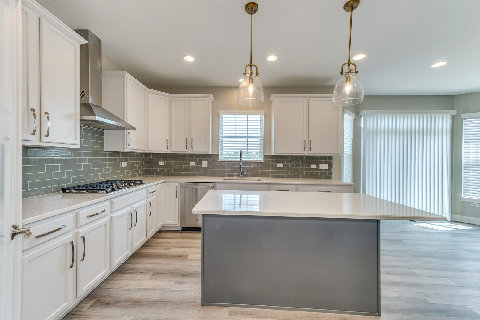 13101 Kettering Way Lemont, IL 60439 - Photo 10 of 36 a large kitchen with granite countertop a stove a sink a refrigerator and white cabinets with wooden floor