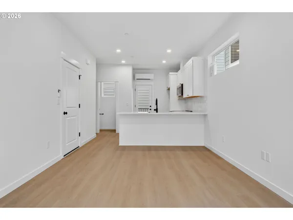 a kitchen with stainless steel appliances granite countertop a sink a stove and a refrigerator with wooden floor