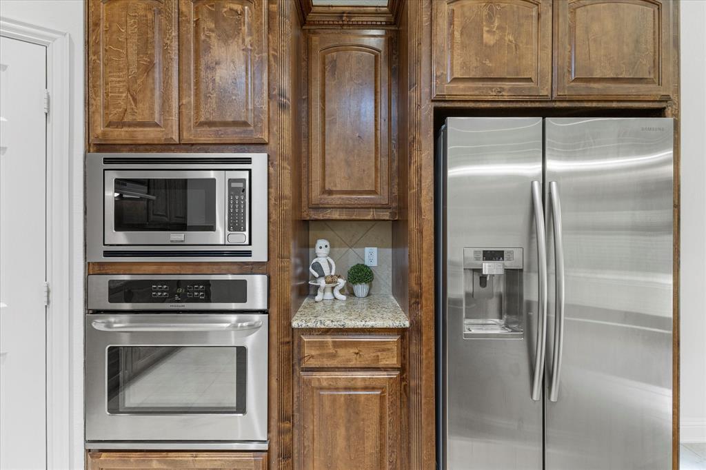 204 Tower Circle Terrell, TX 75160 - Photo 21 of 35 a kitchen with granite countertop stainless steel appliances and wooden cabinets