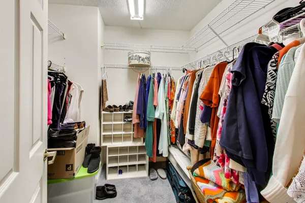 a view of walk in closet with clothes and shoes