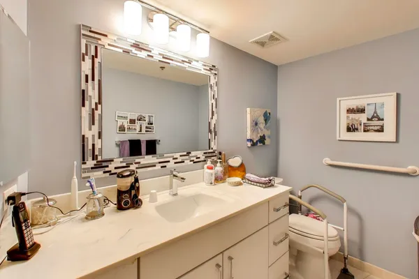 a bathroom with a sink mirror and toilet