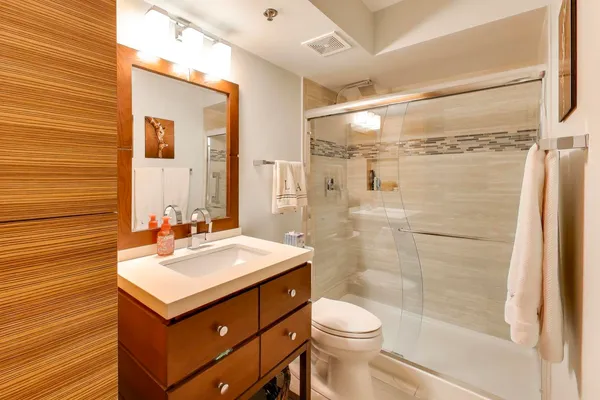 a bathroom with a sink mirror toilet and shower