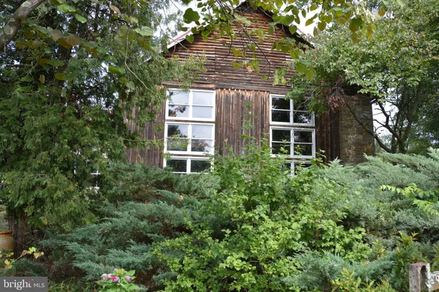a dining room with wooden floor a chandelier a wooden table and chairs