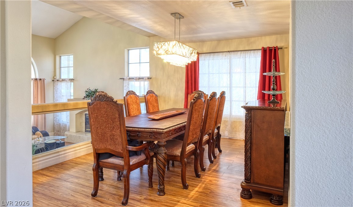 3704 North Campbell Road Las Vegas, NV 89129 - Photo 9 of 38 Elegant dining area features vaulted ceilings and rich wood flooring, ideal for entertaining.