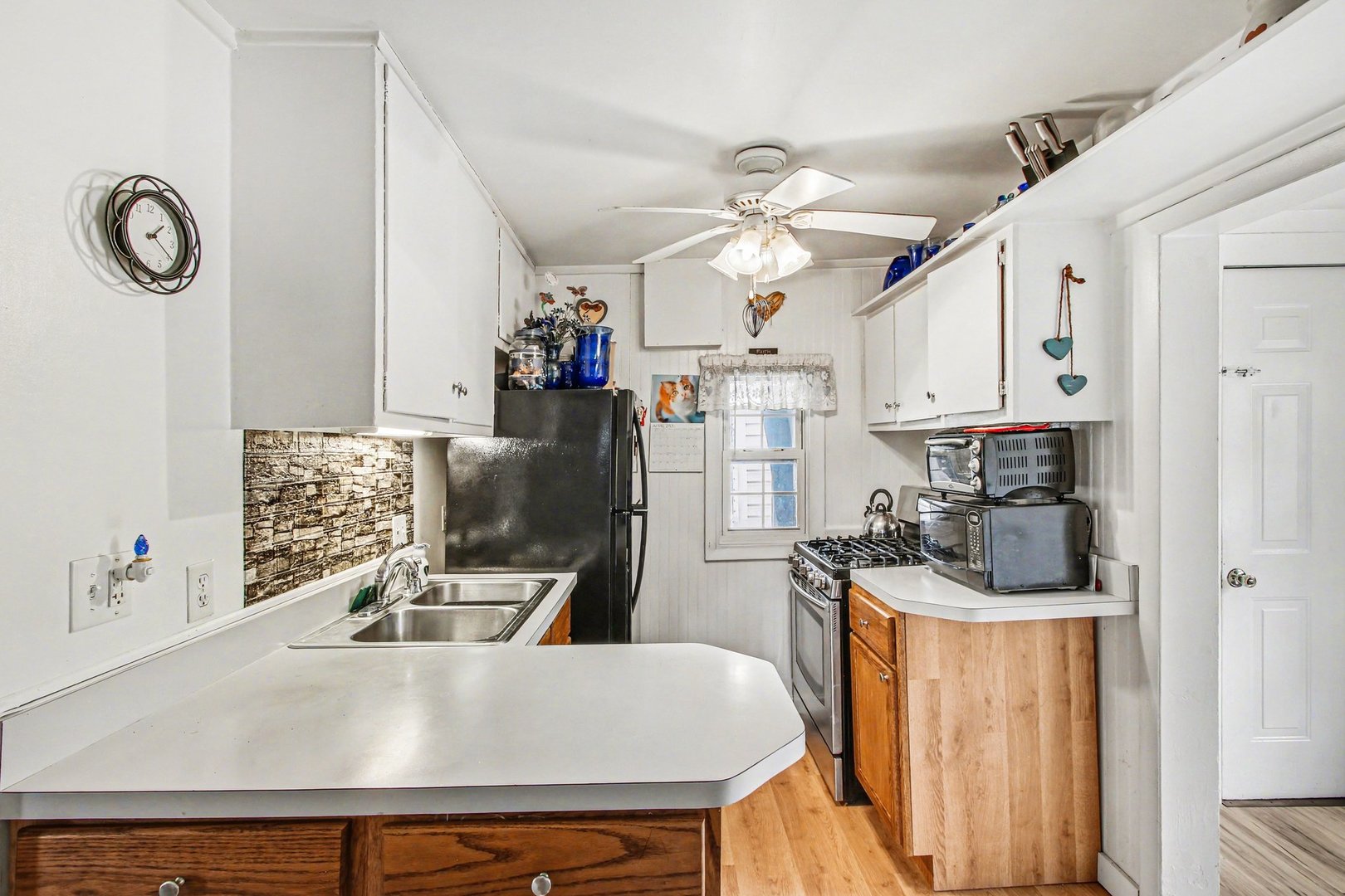 5335 Stone Avenue Portage, IN 46368 - Photo 9 of 17 a kitchen with stainless steel appliances granite countertop a sink a stove top oven a clock and cabinets