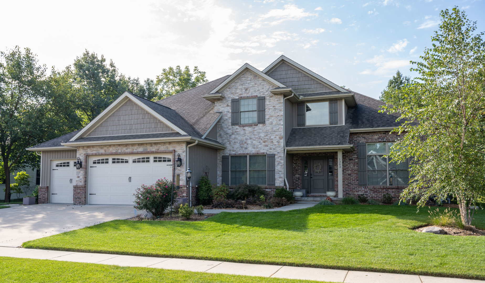 1303 East White Oak Road Mahomet, IL 61853 - Photo 1 of 64 a front view of a house with a yard and garage