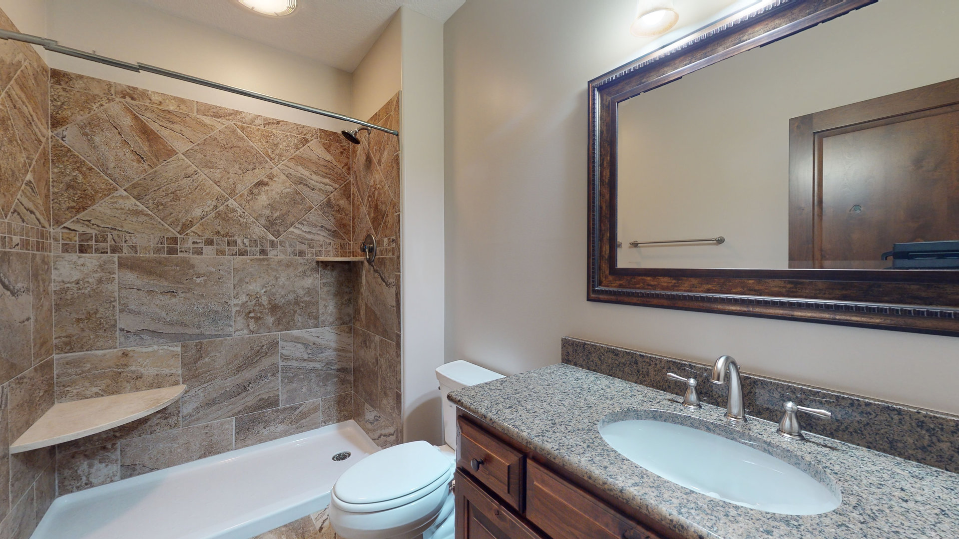 1303 East White Oak Road Mahomet, IL 61853 - Photo 41 of 64 a bathroom with a granite countertop sink toilet a mirror a bathtub and shower
