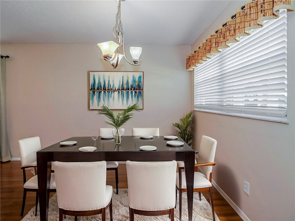 110 Spring Lake Court, Unit 102 Vero Beach, FL 32962 - Photo 11 of 33 a view of a dining room with furniture and wooden floor