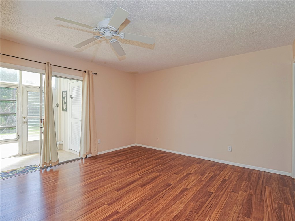 110 Spring Lake Court, Unit 102 Vero Beach, FL 32962 - Photo 17 of 33 a view of an empty room with wooden floor and a ceiling fan