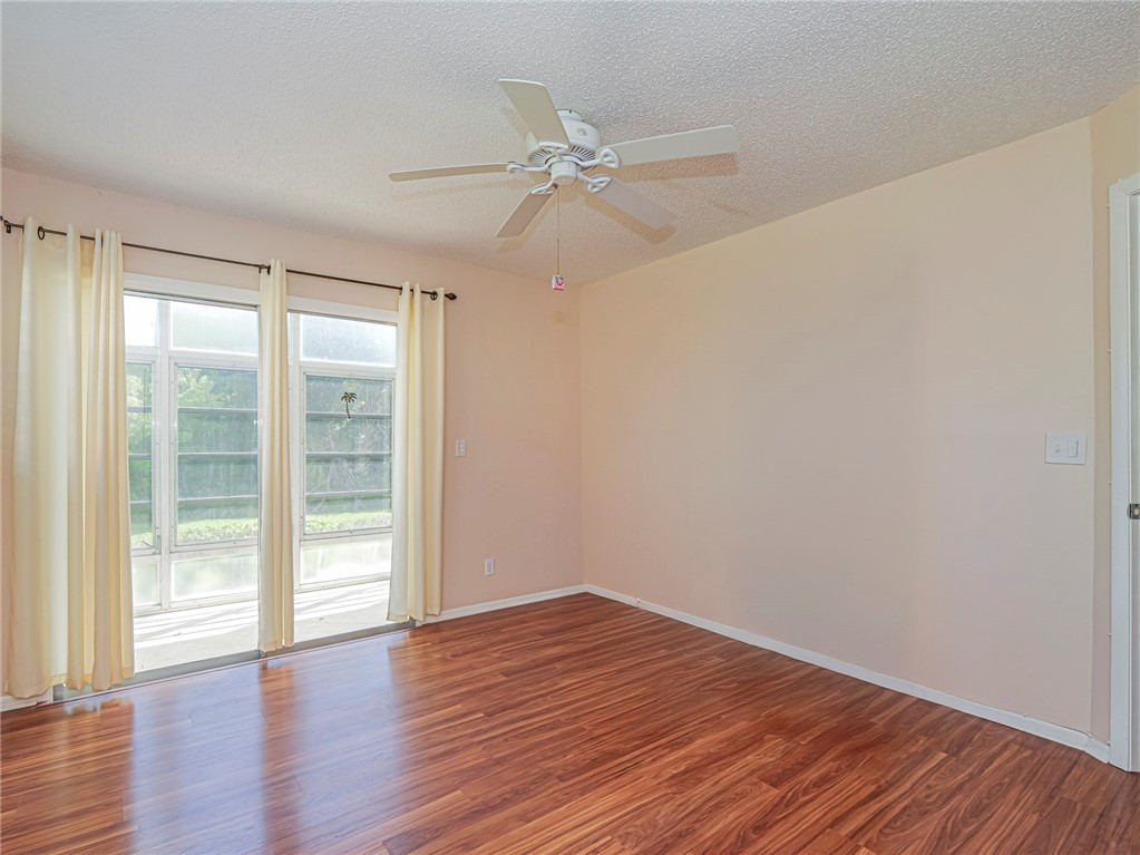 110 Spring Lake Court, Unit 102 Vero Beach, FL 32962 - Photo 24 of 33 a view of an empty room with wooden floor and a window