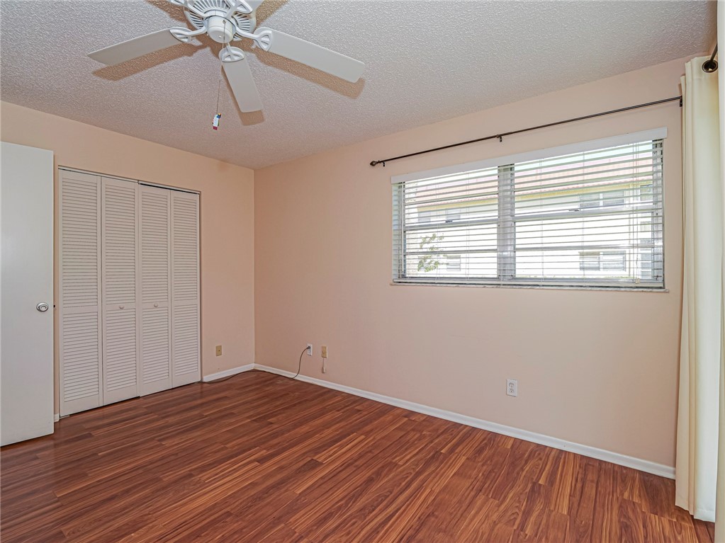 110 Spring Lake Court, Unit 102 Vero Beach, FL 32962 - Photo 25 of 33 a view of an empty room with wooden floor and a window