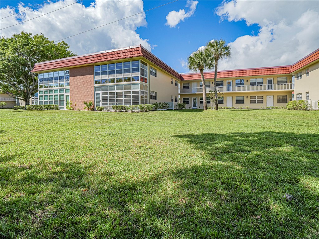 110 Spring Lake Court, Unit 102 Vero Beach, FL 32962 - Photo 31 of 33 a front view of a house with a garden