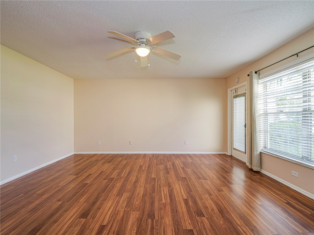 110 Spring Lake Court, Unit 102 Vero Beach, FL 32962 - Photo 4 of 33 a view of an empty room with wooden floor and a window