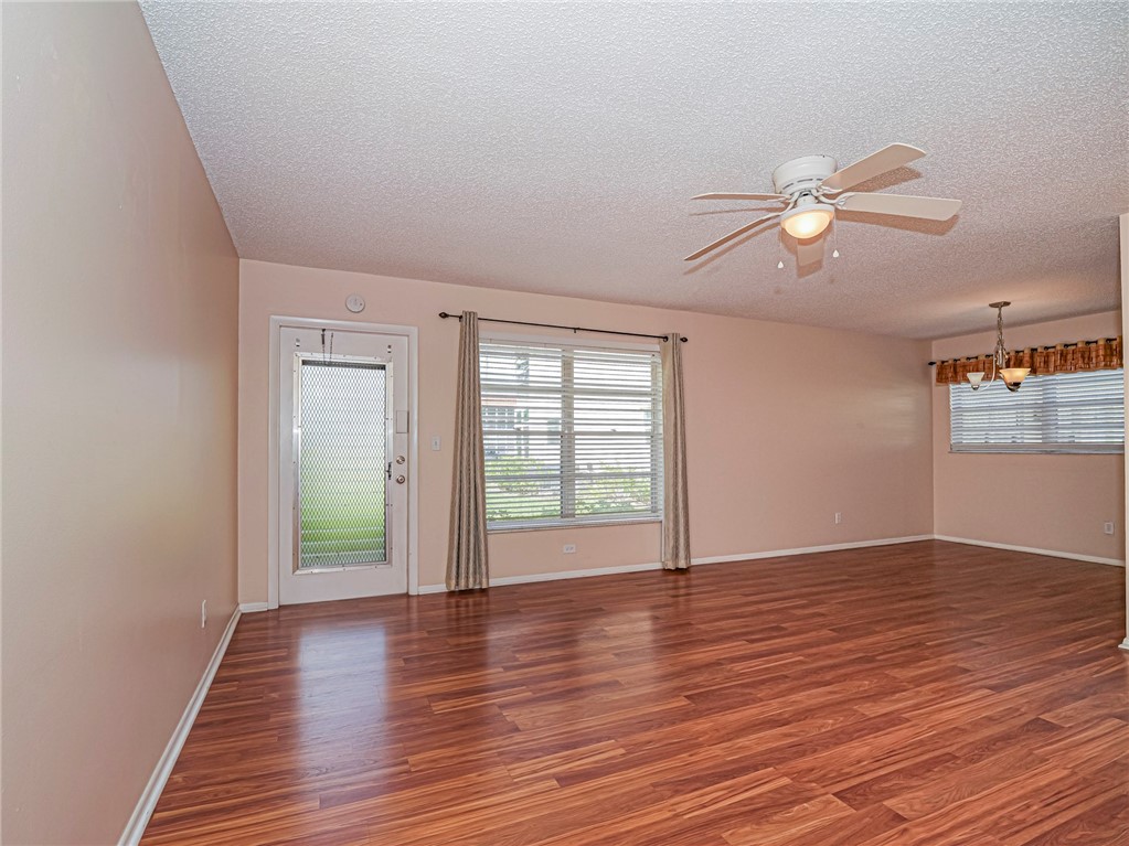 110 Spring Lake Court, Unit 102 Vero Beach, FL 32962 - Photo 6 of 33 a view of an empty room with a window and wooden floor