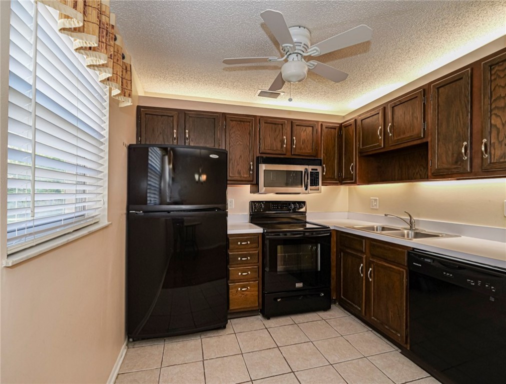 110 Spring Lake Court, Unit 102 Vero Beach, FL 32962 - Photo 9 of 33 a kitchen with stainless steel appliances granite countertop a refrigerator a sink a stove top oven and cabinets