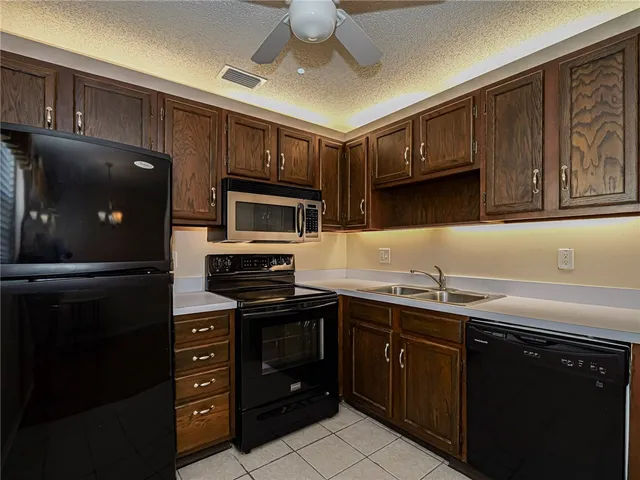 a kitchen with a sink a stove and cabinets