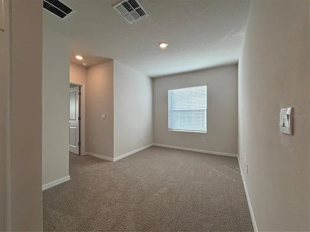 a kitchen with granite countertop a stove top oven a sink and white cabinets with wooden floor