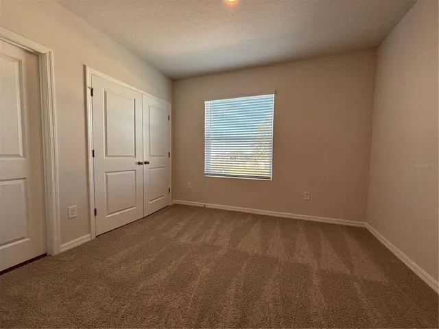 a bathroom with a toilet and a wooden floor