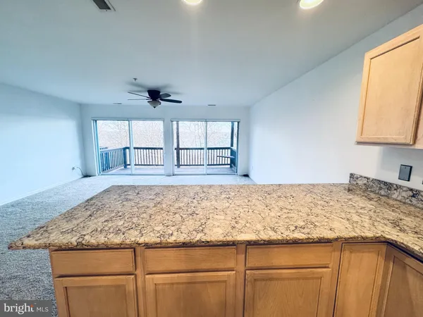 a kitchen with kitchen island granite countertop stainless steel appliances and wooden cabinets
