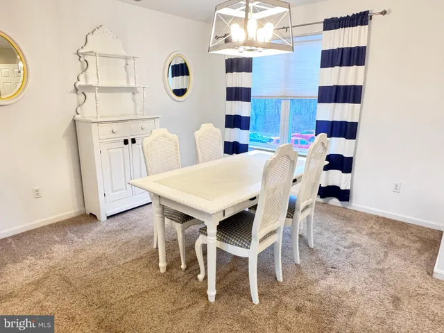 a view of a dining room with furniture and chandelier