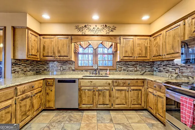a living room with stainless steel appliances granite countertop furniture a rug and a window