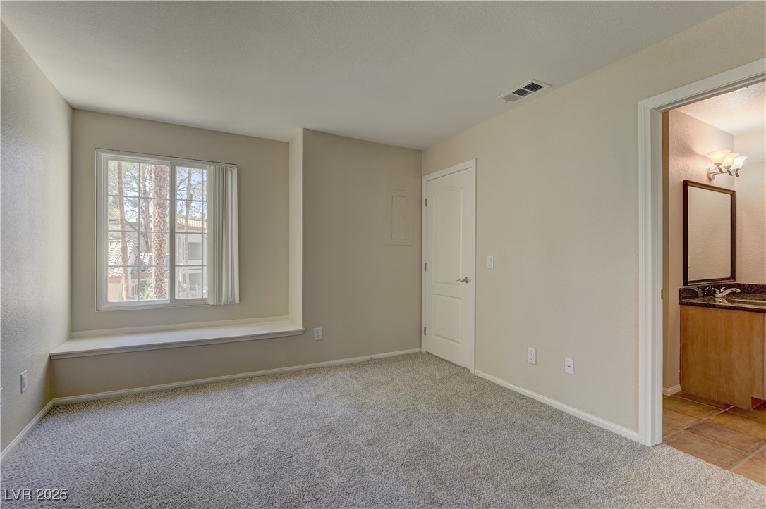 3145 East Flamingo Road, Unit 2080 Las Vegas, NV 89121 - Photo 16 of 26 Unfurnished bedroom featuring carpet flooring, baseboards, and ensuite bath