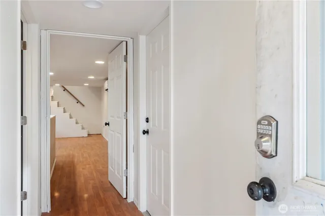 a view of an empty room with a window and wooden floor