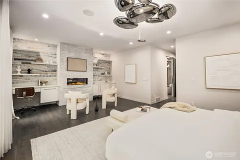 a bedroom with a bed a chandelier and dresser