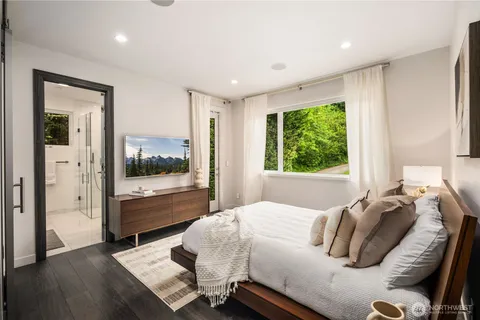 a bedroom with a bed and large window with outer view