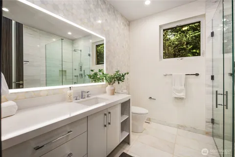 a bathroom with a double vanity sink toilet and shower