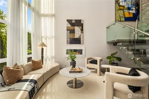 a living room with furniture and floor to ceiling windows