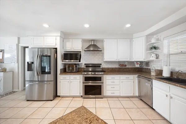 a kitchen with stainless steel appliances granite countertop a refrigerator and a sink