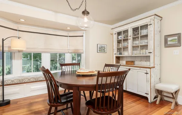 a dining room with furniture window and wooden floor
