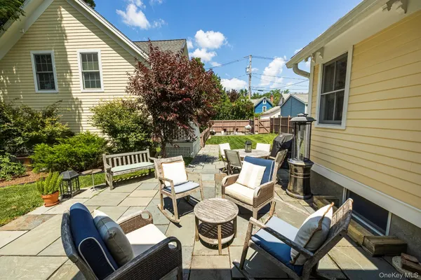 a view of a patio with couches table and chairs and potted plants