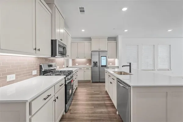 a kitchen with stainless steel appliances granite countertop lots of counter space and a sink