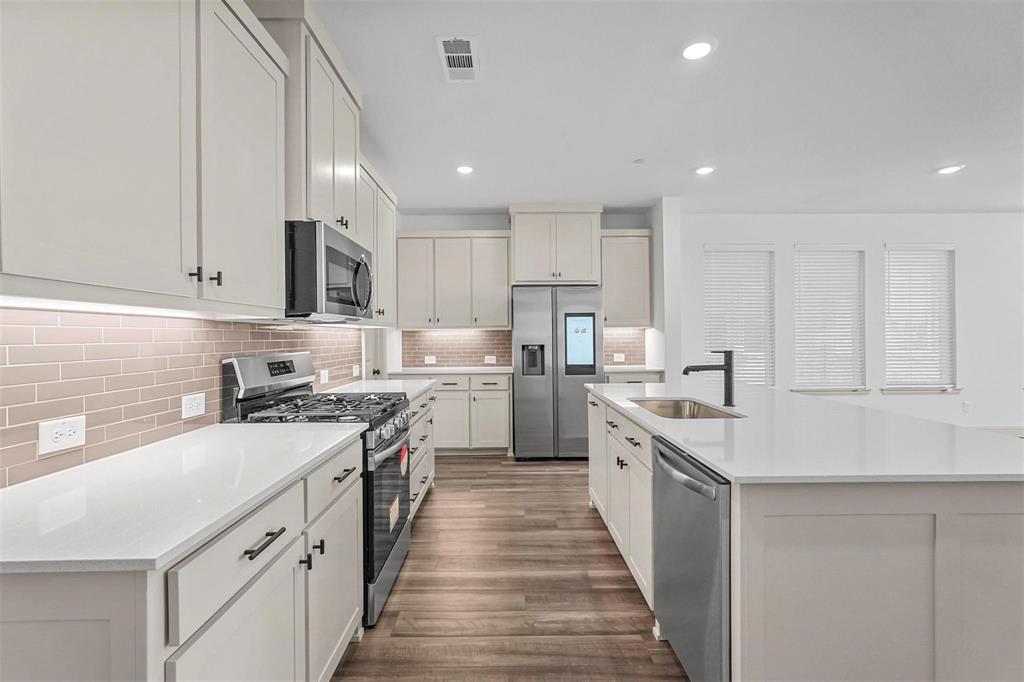 2640 Bluejack Road McKinney, TX 75071 - Photo 12 of 18 a kitchen with stainless steel appliances granite countertop lots of counter space and a sink