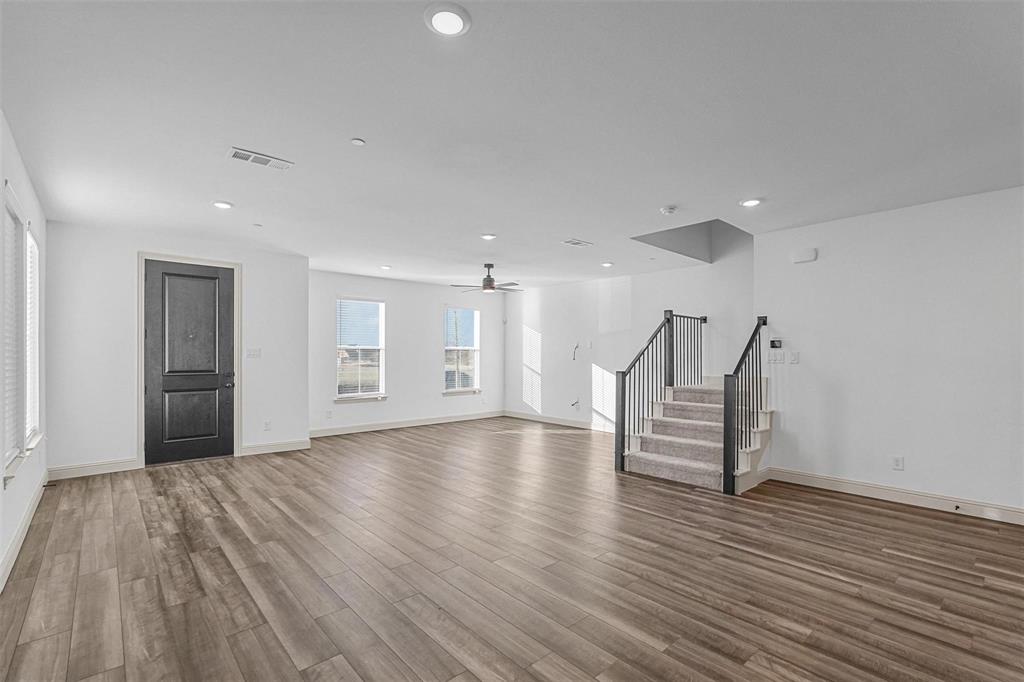 2640 Bluejack Road McKinney, TX 75071 - Photo 6 of 18 a view of empty room with wooden floor and kitchen
