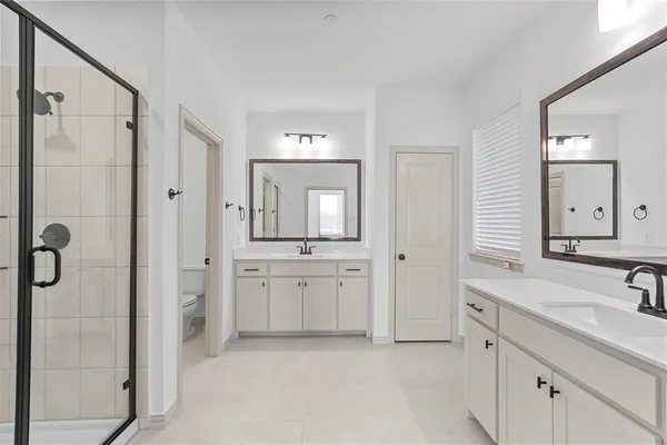 a spacious bathroom with a double vanity sink mirror and shower