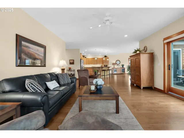 a kitchen with stainless steel appliances granite countertop a stove a sink a refrigerator and a dining table with wooden floor