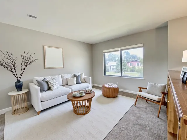 a living room with furniture a window and a flat screen tv