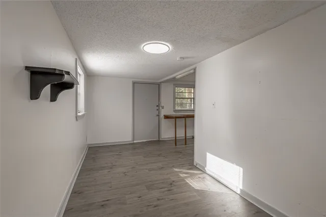 an empty room with a ceiling fan and windows