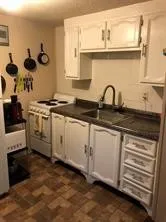 a white kitchen with a sink and cabinets