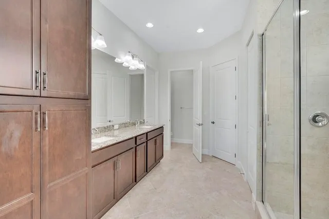 a bathroom with a double vanity sink mirror and shower