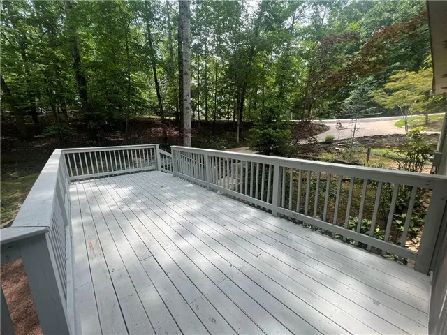 a balcony with wooden floor and trees